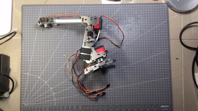 A desktop robotic arm assembled from individual mechanical parts and servos