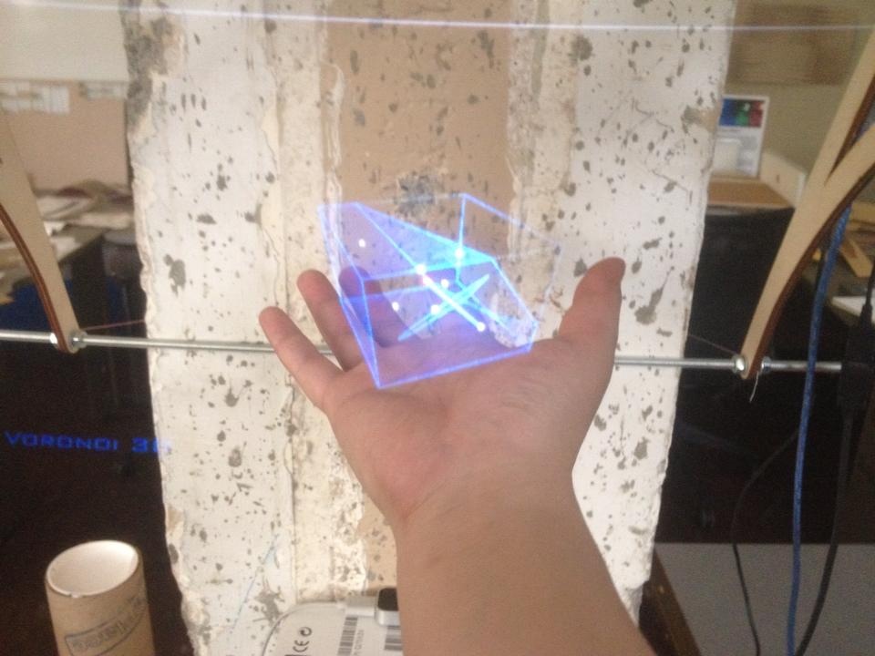 A digital wireframe appears above the user’s hand in the InSpire display