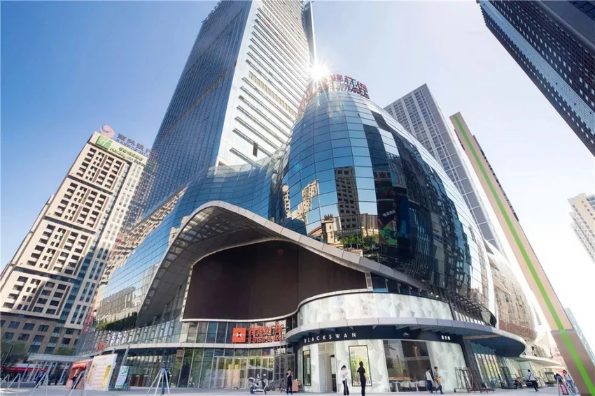 Built podium entrance beneath its curved glazed envelope
