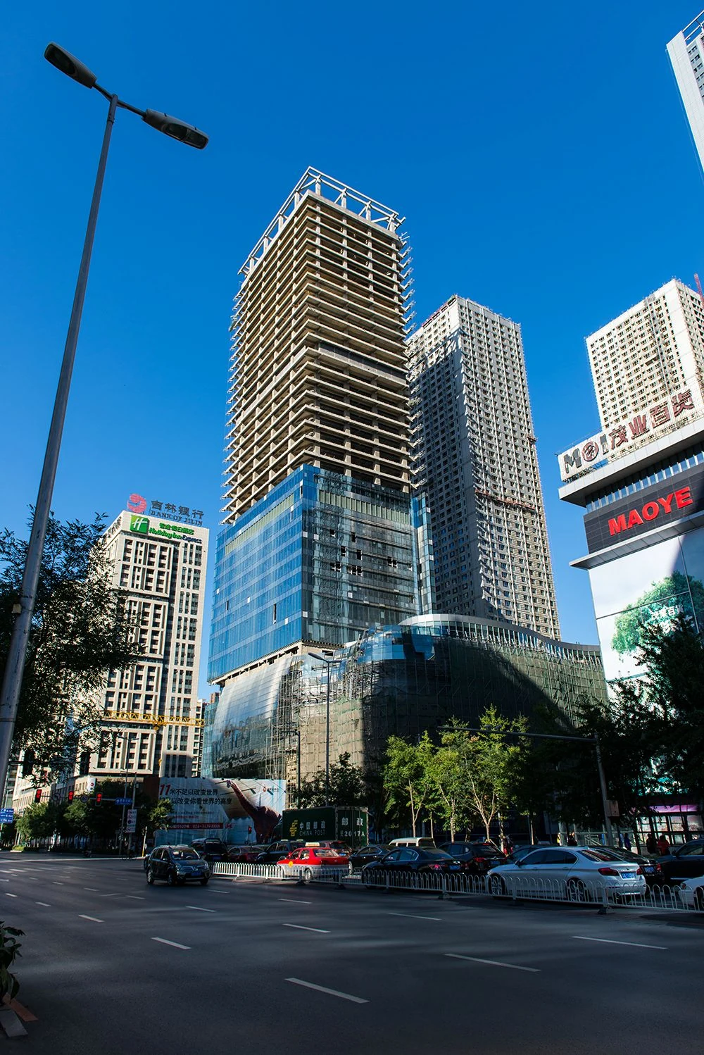 Tower and podium curtain walls being installed during construction