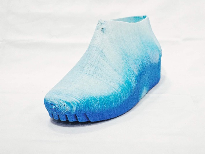 Three-quarter view of the printed sneaker, with material gradients from the pale upper to the blue sole and toe