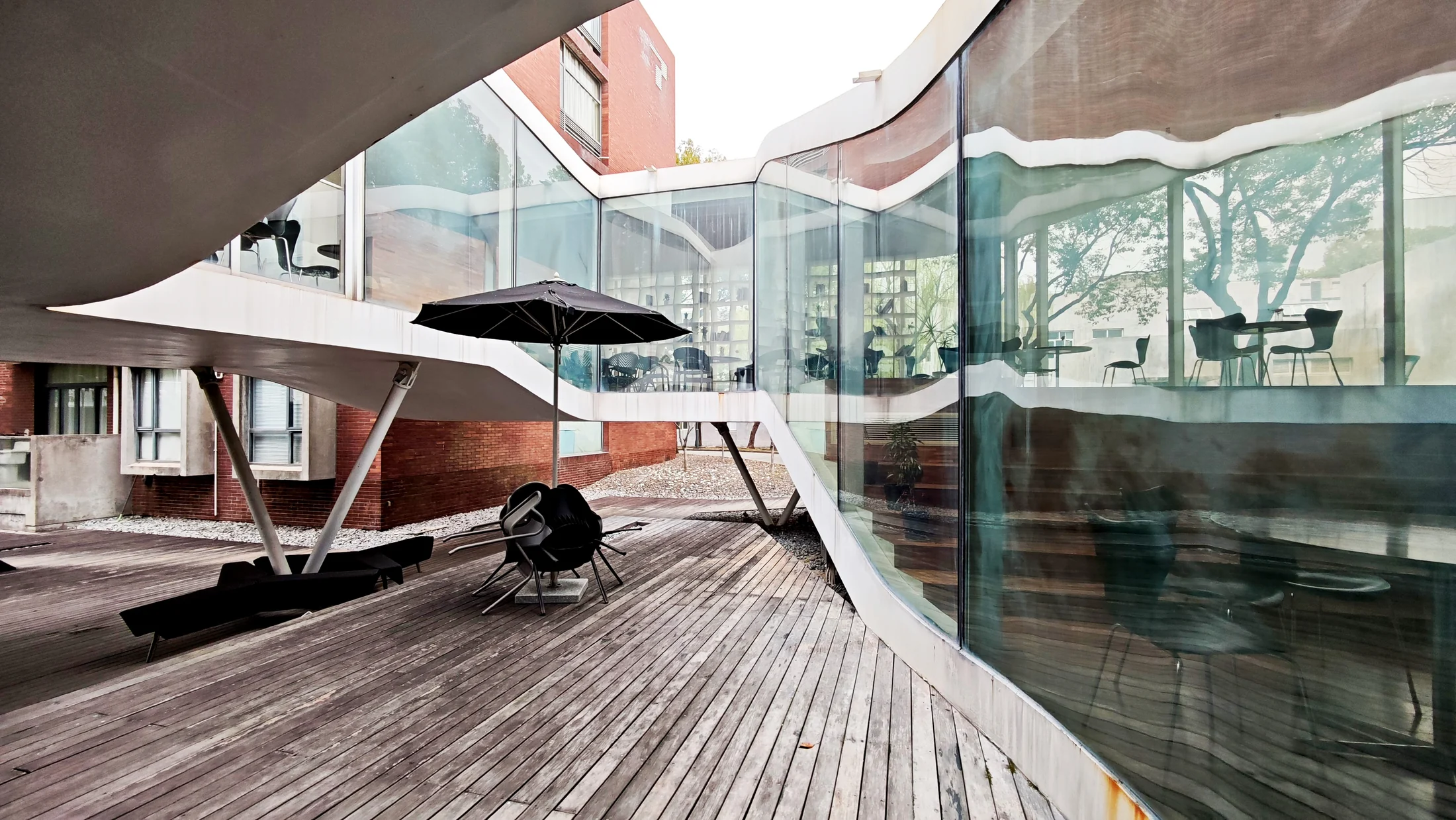Curved glazing maintains views across the courtyard as the interior rises around it.
