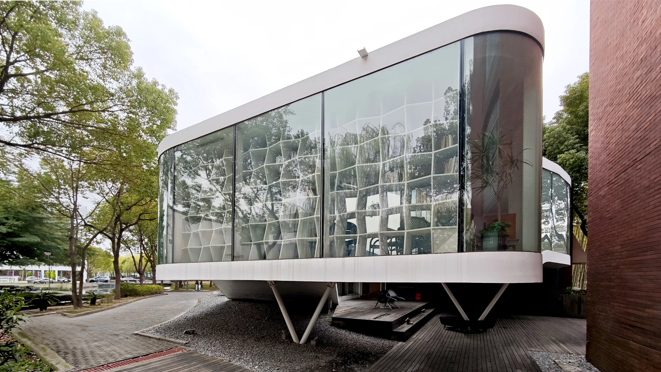 The raised reading area follows the curved glazed edge above the campus path.