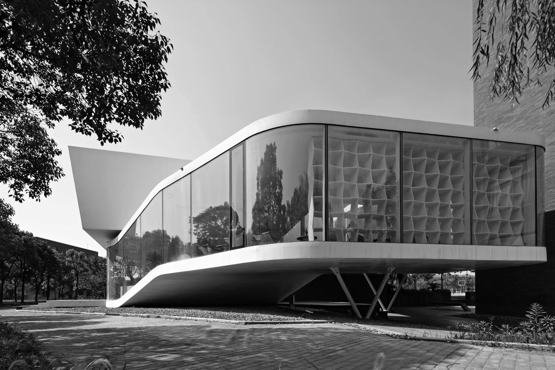 A continuous white edge traces the changing floor level; V-shaped supports leave the ground open.