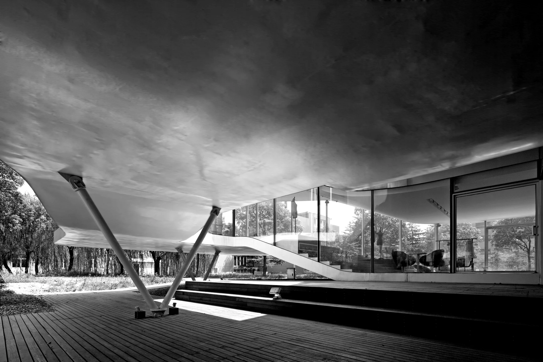 The lifted floor forms a sheltered outdoor space above the timber deck.