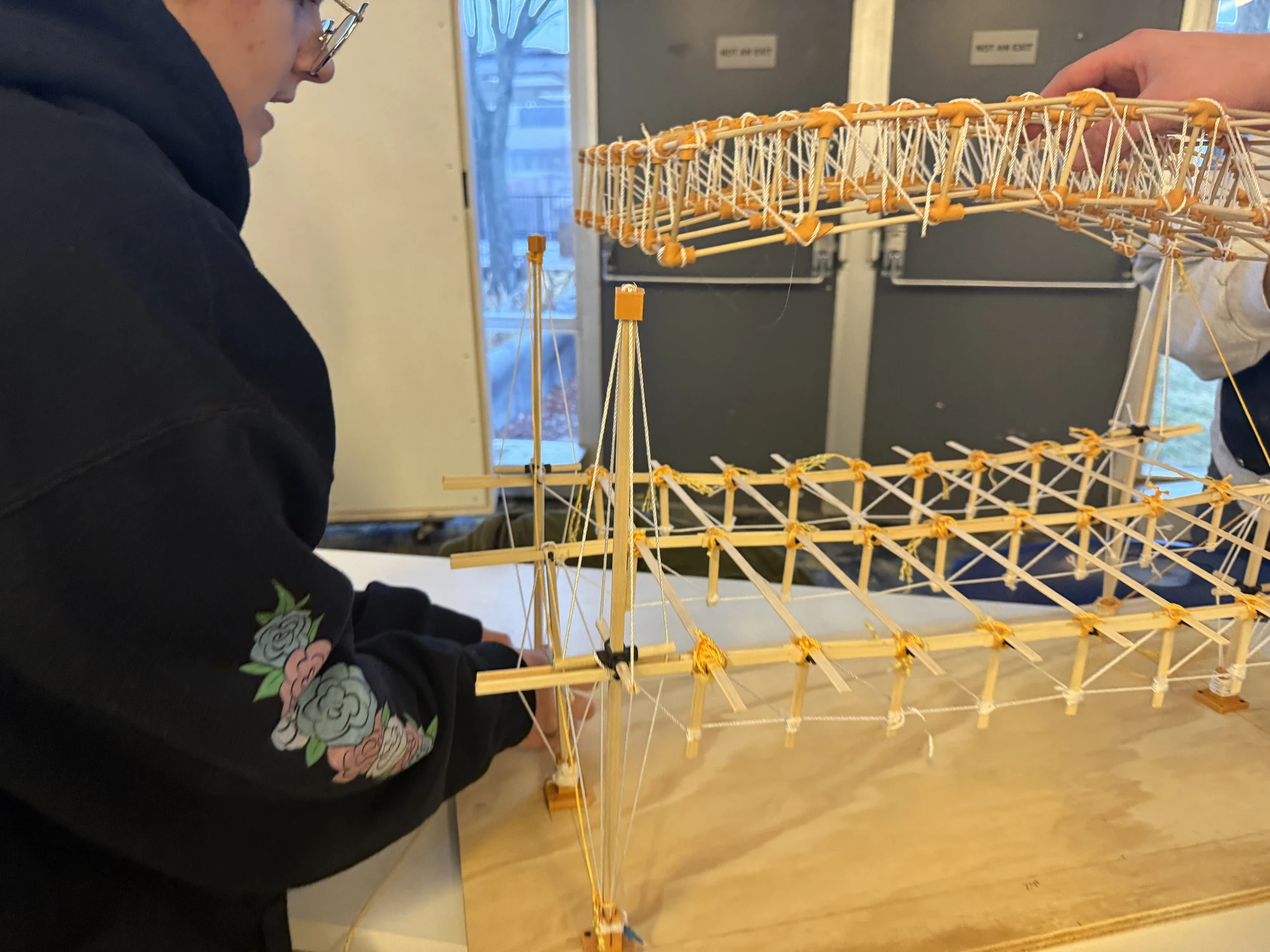Lucas Guldner, Nick Henderson, Dylan Ries, and Gretchen Ullrich — assembling the space-truss roof above the floor and stayed columns