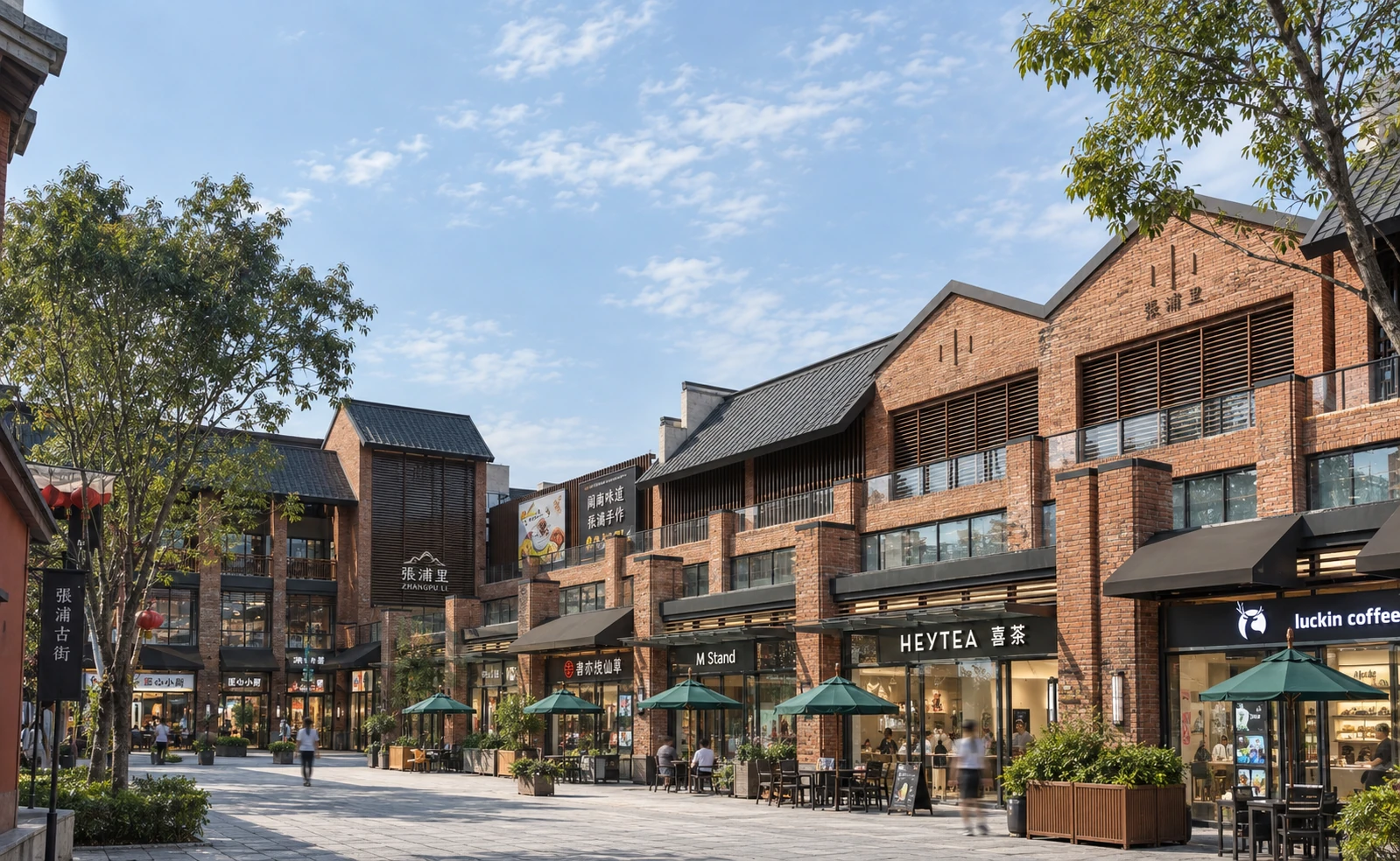 Completed pedestrian retail street with red-brick façades, outdoor seating, timber screens, and mature trees