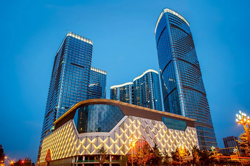 Night view of the completed towers and illuminated podium